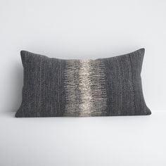 a black and white striped pillow sitting on top of a table next to a wall