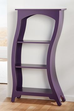 a purple book shelf sitting on top of a hard wood floor next to a white wall