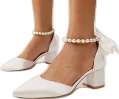 a woman wearing white shoes with pearls on the ankle