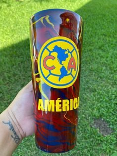 a person holding up a red glass with the word america painted on it