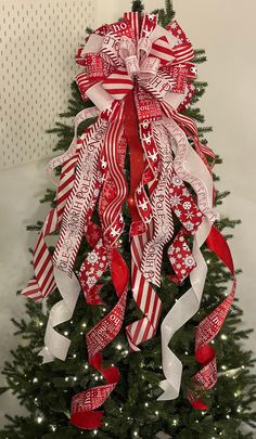 a christmas tree decorated with red and white ribbons