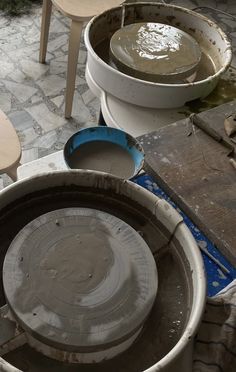 several buckets and tables sitting on top of a stone floor