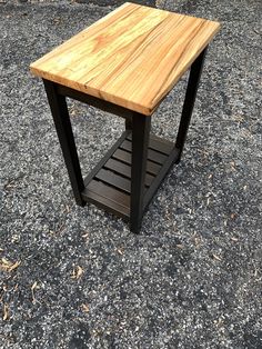 a wooden table sitting on top of a gravel ground