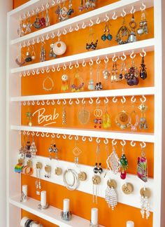 an orange and white wall with jewelry on it's shelves in front of the door