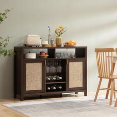 a small bar with wine glasses and bottles on the top, next to a dining room table