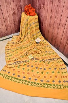 An elegant collection with fine traditional meenakari weaving on the body and pallu that comes with hand bandhani work and meenakari work on the border and pallu makes this saree one of the magnetic works in an off-white color. Color: A shade of turmeric yellow color Technique: Amazing work of meenakari weaving with traditional weaving on the rest of the saree and hand bandhej work fused together Fabric: Georgette Quality: Indyvogue's Assurance of Pure Silk Mark Certified Saree Yellow Bandhani Saree, Yellow Bandhani Print Saree For Puja, Bandhani Yellow Saree, Yellow Unstitched Meenakari Saree, Yellow Bandhani Print Unstitched Saree, Latest Sarees, Kinds Of Fabric, Color Techniques, Work Sarees