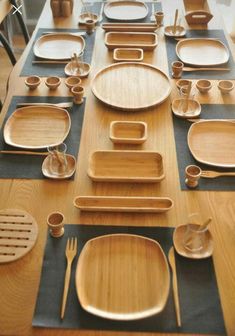 a wooden table topped with lots of plates and bowls