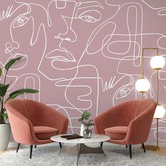 two chairs and a table in front of a pink wall with white lines on it