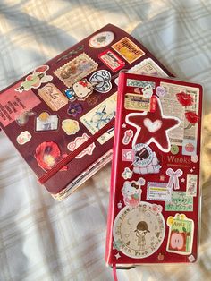 two red suitcases covered in stickers on a bed