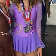 two women standing next to each other wearing medals