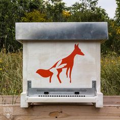 a red fox sign on the side of a wooden fence with trees in the background