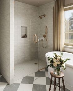 a bath room with a stand up shower and a checkerboard floored floor