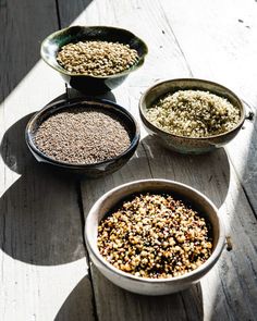 three bowls filled with food sitting on top of a wooden table