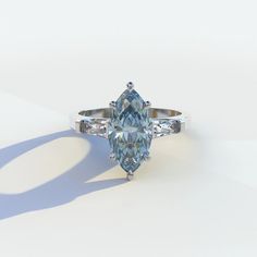 an oval cut blue diamond ring on a white background