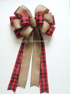 a red and black checkered bow on a white surface with the words simply adornments above it