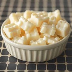 a bowl filled with cheese sitting on top of a table next to a black and white checkered cloth