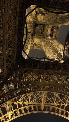 the eiffel tower lit up at night with its lights on and below it