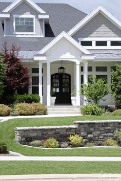 the front entrance to a house with landscaping around it