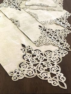 four pieces of white lace on top of a wooden table