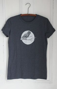 ** Please refer to the sizing chart before ordering to ensure the correct fit! **This Owl Tee is designed and hand-printed in our Maine studio using eco-friendly, water-based ink. Each shirt is sewn in Haiti for a living wage using US organic and recycled fibers. The tri-blend fabric is soft and super comfy!DETAILS:* Original Hearth and Harrow design* White print on dark blue* Crew neck * 25% organic US cotton / 50% recycled polyester from plastic bottles / 25% TENCEL Modal   * Each shirt contai Screen Print Fitted Crew Neck T-shirt, Fitted Crew Neck T-shirt With Screen Print, Fitted Crew Neck Shirt With Screen Print, Tri-blend Crew Neck T-shirt With Screen Print, Beautiful Tshirts, Owl T Shirt, Blue Crew, Bird Print, Women's T Shirts