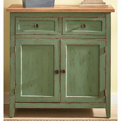 an old green cabinet with two doors and drawers