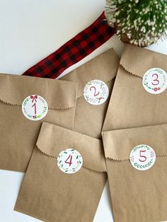 four brown paper bags with numbers on them and a christmas tree in the middle one