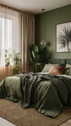 a bed with green sheets and pillows in a bedroom next to a large painting on the wall