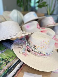 The wait is over! This hat is Ready to Ship and your order will be processed and shipped within 3-7 business days. Items with embroidery customization will be shipped within 2 weeks. White Palm Straw Hat with Pink and Yellow Floral and Star Design by Corazon Playero. Custom designed and hand made hats by artisans in San Jose Del Cabo, Mexico. These hats are one size fits most with an elastic band inside to add comfort and fit for all head sizes. Please note, all hats come with natural braid unle Custom Straw Hats, Embroidered Straw Hat, Leather Burning, San Jose Del Cabo Mexico, Hats Ideas, Hat Decor, Hat Bar, Custom Made Hats, Cabo Mexico