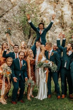 a group of people standing next to each other with their arms in the air and holding flowers