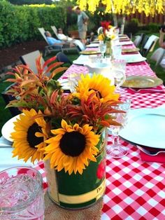 the table is set with sunflowers and place settings