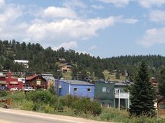 a street sign on the side of a road in front of some houses and trees