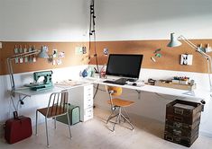 a desk with a laptop computer sitting on top of it next to a chair and lamp