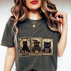 🔮 Unleash Your Feline Fortune with the Black Cat Tarot Shirt! 🔮 Cast a spell on your style this Halloween with our bewitching Witchy Shirt, adorned with not one, not two, but three mystically mischievous black cat tarot cards! Embrace the vintage fall vibes and add a dash of spooky sophistication to your wardrobe. Don't let your chance to be the Cat's Meow this Halloween slip away! Be the first to snatch this Spooky Tee and become the ultimate fashion sorceress in your coven. So, whiskers or n Halloween Cotton Tops With Cat Design, Fitted Black Top With Cat Design, Spooky Cotton Tops With Cat Design, Spooky Cotton Top With Cat Design, Spooky Halloween Cat Design Top, Cat Tarot Cards, Black Graphic Tee With Cat Print, Halloween Cat Print Crew Neck Top, Shirt Knot