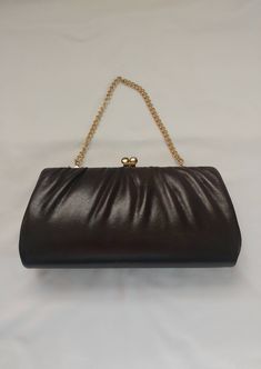 "This elegant 1970s/1980s Brown Purse is the perfect vintage accessory to finish your evening look! This deep brown leather purse has a retro charm with gold tone metal accents. The chain handle can be tucked inside, which turns the purse into a clutch. This classy purse is great for a gift or to accessorize for a special occasion! Purse measures 9\" wide x 5\" across x 1 1/2\" thick laid flat, 5\" chain pulled taught * Light rusting on the metal, light wear on the stitching, nice condition over Brown Leather Clutch With Chain Strap, Vintage Leather Evening Bag, Vintage Leather Evening Bag For Party, Retro Brown Bags For Party, Retro Brown Bag For Party, Retro Brown Party Bag, Retro Brown Party Bags, Vintage Brown Evening Bag For Party, Vintage Formal Clutch With Chain Strap