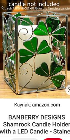 the candle holder is made out of stained glass and has green leaves on it's sides