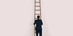 a man standing in front of a ladder with his back to the camera and looking down