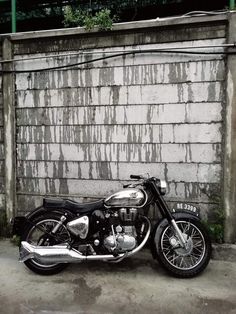 a motorcycle parked in front of a brick wall