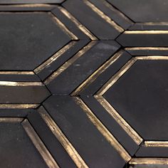 the black and gold tiles are arranged in a hexagonal pattern on the floor