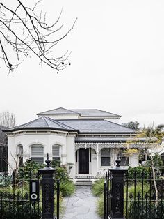 a white house with a black gate in front of it