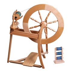 a wooden spinning wheel and two spools of thread