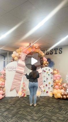 a woman is standing in front of some balloons