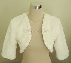 "All of our items are handmade and unique to our company.  Soft faux Fur shrugs with 3/4 length sleeves, available in ivory and black. These stunning boleros are luxuriously soft and are fully lined with a matching satin lining. They are finished to a high standard. Perfect to finish the look! Available in black, ivory, grey and navy Lots of other styles/colours available, click on link below to view my Etsy shop -  https://www.etsy.com/uk/shop/dazzlingladieswear?ref=hdr_shop_menu Approximate measurements/sizes - XS - UK 4-6 / US 1-2 / Europe 32 -34 Shoulders - 15\" / 38cm - To fit chest 30\" - 33\" / 76cm - 84cm S - UK 8-10 / US 4-6 / Europe 36-38 Shoulders - 16\" / 40.5cm - To fit chest 33\" - 36\" / 84cm - 91.5cm M - UK 12-14 / US 8-10 / Europe 40-42 Shoulders - 17\" / 43cm - To fit che Cream Fitted Outerwear For Wedding, Elegant White Outerwear With 3/4 Sleeves, White 3/4 Sleeve Outerwear For Winter, White Fitted Outerwear With 3/4 Sleeves, Bolero Sleeves, Shoulder Shrug, Bolero Jacket Wedding, Faux Fur Bolero, Faux Fur Wedding