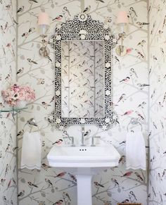 a white sink sitting under a bathroom mirror next to a wall mounted faucet