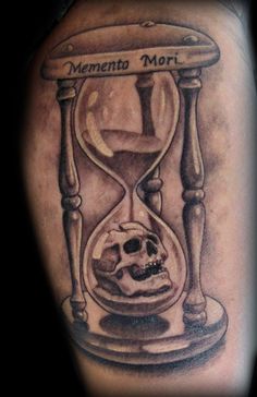 a man with a tattoo on his arm that has an hourglass and a skull in it