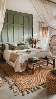 a bedroom with a bed, wicker chair and green painted headboard on the wall