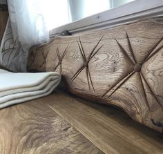 a wooden bench sitting on top of a hard wood floor next to a white curtain