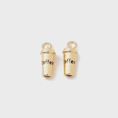 two small gold coffee cups with the words coffee on them