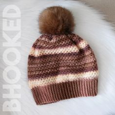 a knitted hat with a pom - pom sitting on top of it