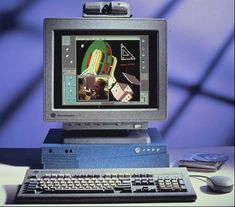 an old computer monitor sitting on top of a desk next to a keyboard and mouse