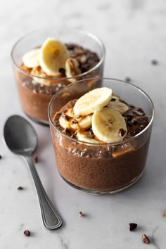 two glasses filled with chocolate pudding topped with banana slices